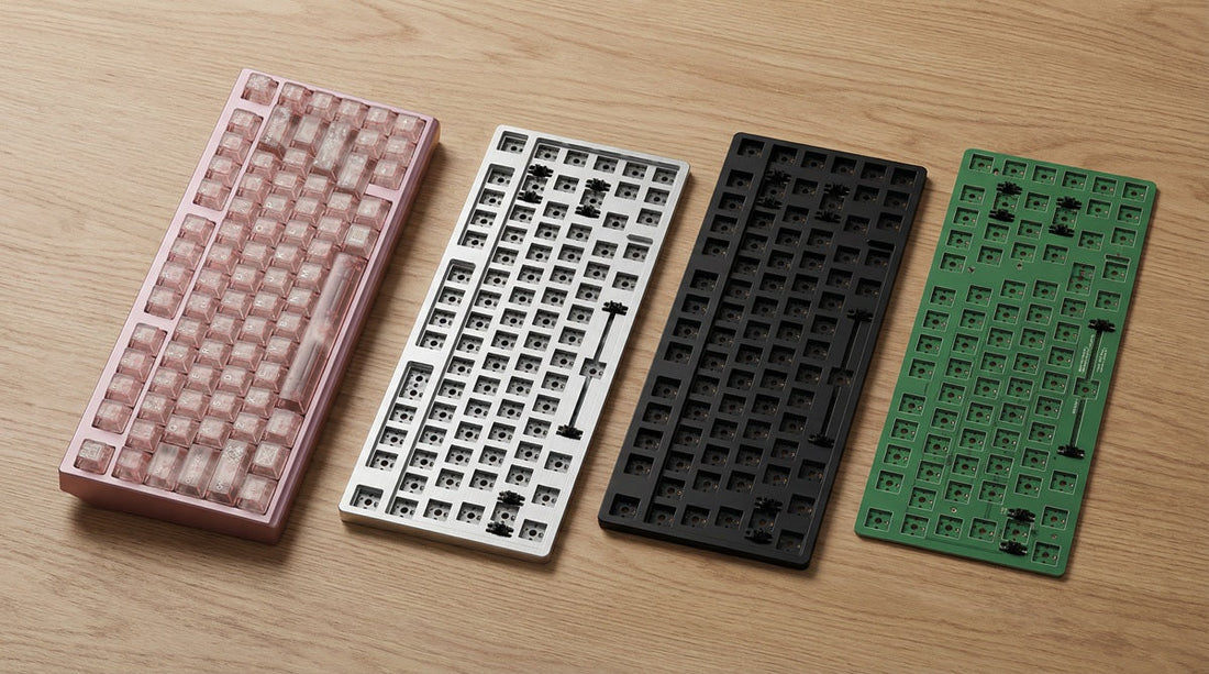 Three different mechanical keyboard plates (Aluminum, Polycarbonate, and FR4) laid out side-by-side on a wooden desk next to an NPKC RO75 PRO keyboard.
